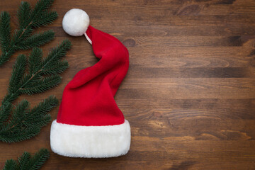 Santa Claus hat on a wooden background with flying snowflakes. Christmas, New Year - Powered by Adobe