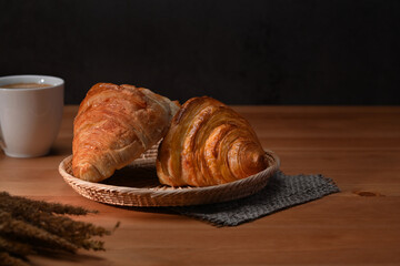 Fresh baked buttery croissants in wicker basket ready to serve. Fresh croissants for breakfast