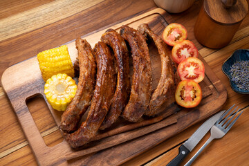 Pork Spare Ribs with Barbecue seasoned spicy basting sauce, Grilled sliced barbecue pork ribs on wooden plate.