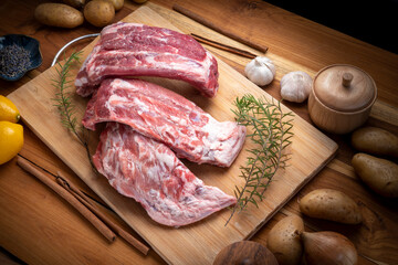 Raw Pork ribs with with a rosemary on wooden plate, Pork Spare Ribs on wooden table.