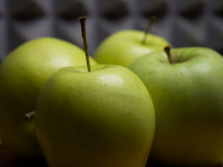 Four large apples, close-up. Fruit on a wooden surface.