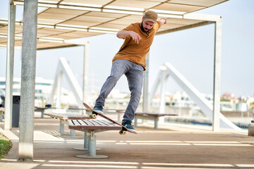 a young man skateboarding on a bank near the harbor