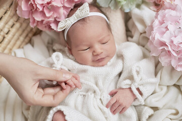 Fototapeta na wymiar Newborn baby girl in flowers. Healthy child. Happy motherhood and parenting