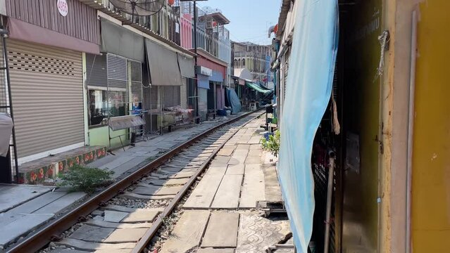 Maeklong, Thailand Circa January 2022 : Train track pass through local umbrella market (Talad Rom Hub), popular tourist destination. Empty market with no tourist daytime    