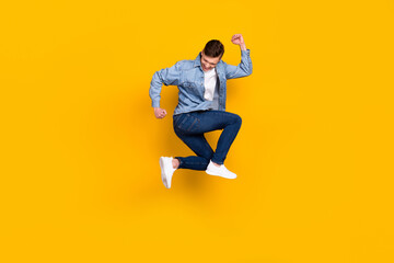 Fototapeta na wymiar Full size profile side photo of young man jump up celebrate luck fists hands triumph isolated over yellow color background