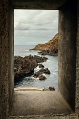 Window view of volcanic island seascape in Porto Moniz (Madeira, Portugal)