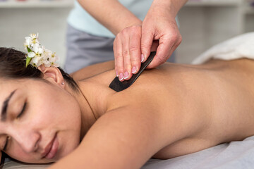 Obraz na płótnie Canvas spa therapist make relax massage with a gouache scraper in salon