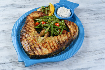 fish steak with asparagus, salmon steak with vegetables, tomatoes, asparagus