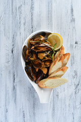 mussels in the shell with sauce, croutons and lemon