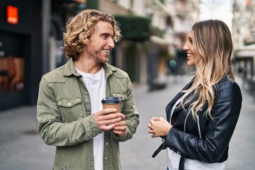 Man and woman couple smiling confident drinking coffee at street