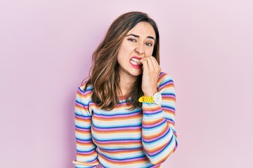 Young hispanic girl wearing casual clothes looking stressed and nervous with hands on mouth biting nails. anxiety problem.