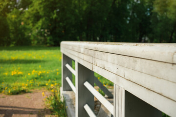 Natural background, the railing of an old bridge in front of the forest, if the selective focus is on the railing. Summer walks in nature, travel on vacation