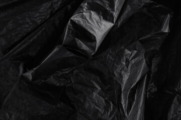 Closeup crumpled single use or non recyclable black color plastic trash bag made from polyethylene...