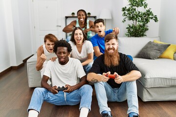 Group of young friends smiling happy playing video game at home.