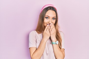 Young blonde girl wearing casual clothes laughing and embarrassed giggle covering mouth with hands, gossip and scandal concept