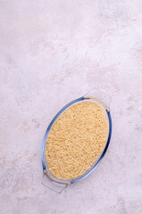 Dry risoni pasta in a glass jar