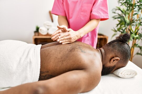Young african american man having back massage at beauty center