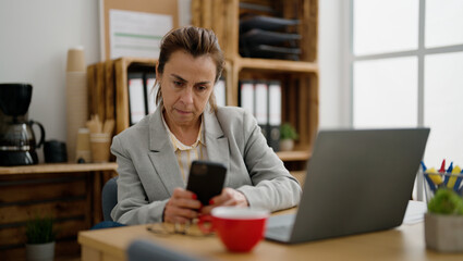 Fototapeta na wymiar Middle age hispanic woman business worker using smartphone at office