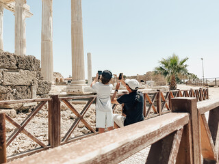 Young father dad and his school boy kid son tourists taking photos of ancient antique coliseum...