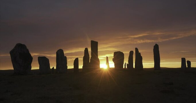 4k cloud and light movement over Callanish Stones at sunrise. Stones in silhouette. No people. Famous prehistoric standing stones, Isle of Lewis, Outer Hebrides, Scotland