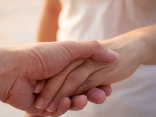 Close up man hand with his girlfriend which  couple express care as psychological support concept, trust warm in happy of love at park