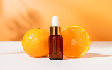 Serum bottle with dropper and slice of orange, ingredients for skin care and treatment vitamin on white background, Natural cosmetics concept.