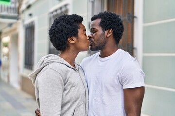 Obraz premium African american man and woman couple hugging each other and kissing at street