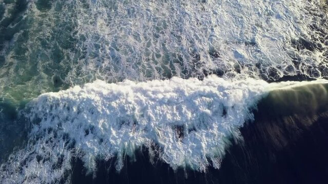 Aerial view overhead waves breaking in the ocean