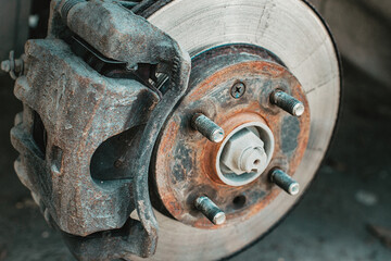 A rusty and old brake disc is serviced or replaced when the car is inspected by a mechanic. Safety and wear of the brake system