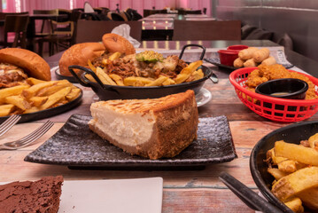 plates of food on a table with cheesecake in the foreground