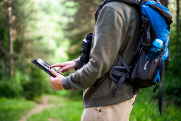 Image of hiker using digital tablet while spending time in nature.