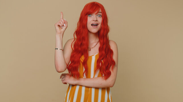 Eureka. Inspired Ginger Woman In Tank Top Pointing Finger Up With Open Mouth, Showing Eureka Solution Idea Gesture, Inspiration, Answer. Young Adult Girl Isolated Alone On Beige Studio Wall Background