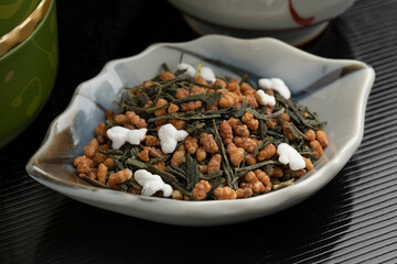 Bowl with Genmaicha, Japanese tea, green tea combined with roasted brown rice, some grains of which have popped close up 