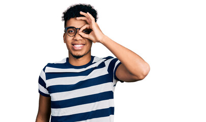Fototapeta premium Young african american man wearing casual clothes and glasses doing ok gesture with hand smiling, eye looking through fingers with happy face.