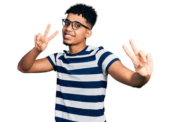 Young african american man wearing casual clothes and glasses smiling looking to the camera showing fingers doing victory sign. number two.
