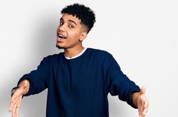 Young african american man wearing casual clothes looking at the camera smiling with open arms for hug. cheerful expression embracing happiness.