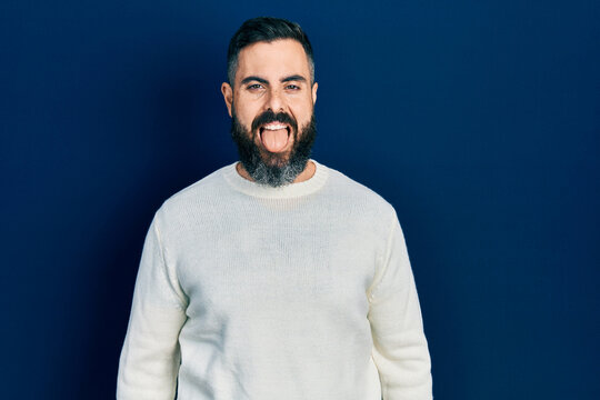 Young hispanic man wearing casual clothes sticking tongue out happy with funny expression. emotion concept.