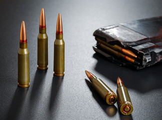 Ammunition for a automatic rifle on black surface with a magazine