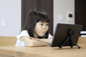 タブレットで動画を見る女子小学生 (7歳)