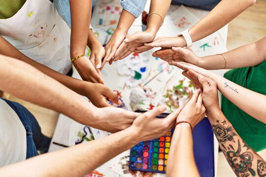 Group of people with hands together art studio.