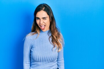 Obraz premium Young hispanic girl wearing casual clothes winking looking at the camera with sexy expression, cheerful and happy face.