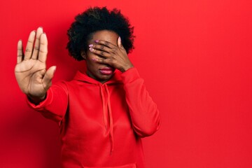 Young african american woman wearing casual sweatshirt covering eyes with hands and doing stop gesture with sad and fear expression. embarrassed and negative concept.