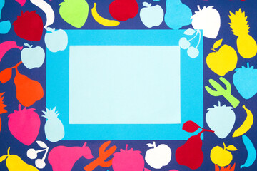 colorful fruit on a dark blue background on which is a blank blue paper with a few fruits on that paper is pastel blue paper as copy space, creative art design, vitamin and healthy food