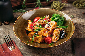 Portion of appetizing fried eggplant salad on served table