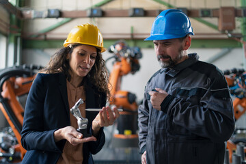 Female engineering manager and mechanic worker doing routine check up in industrial factory