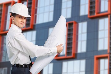 An architect with drawings in his hands. Man supervises construction work. Foreman and construction.