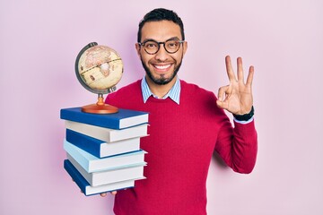 Hispanic man with beard geography teacher doing ok sign with fingers, smiling friendly gesturing...