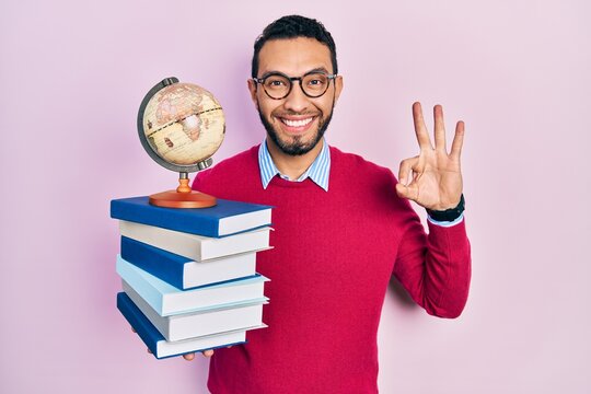 Hispanic Man With Beard Geography Teacher Doing Ok Sign With Fingers, Smiling Friendly Gesturing Excellent Symbol