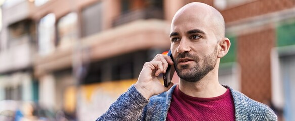 Young man talking on the smartphone at street