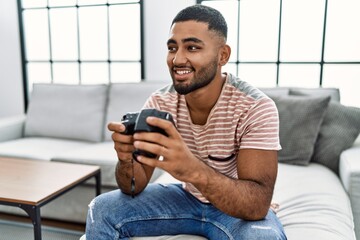 Young arab man smiling confident using camera at home